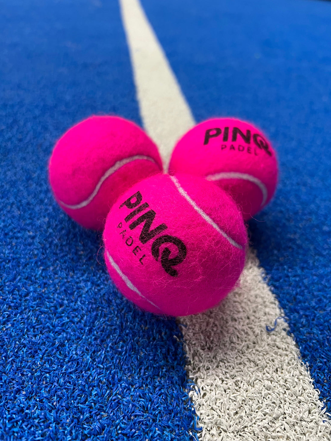 Roze padel ballen van PINQ Padel op padel baan